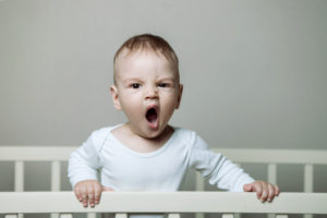 difficult baby standing in crib